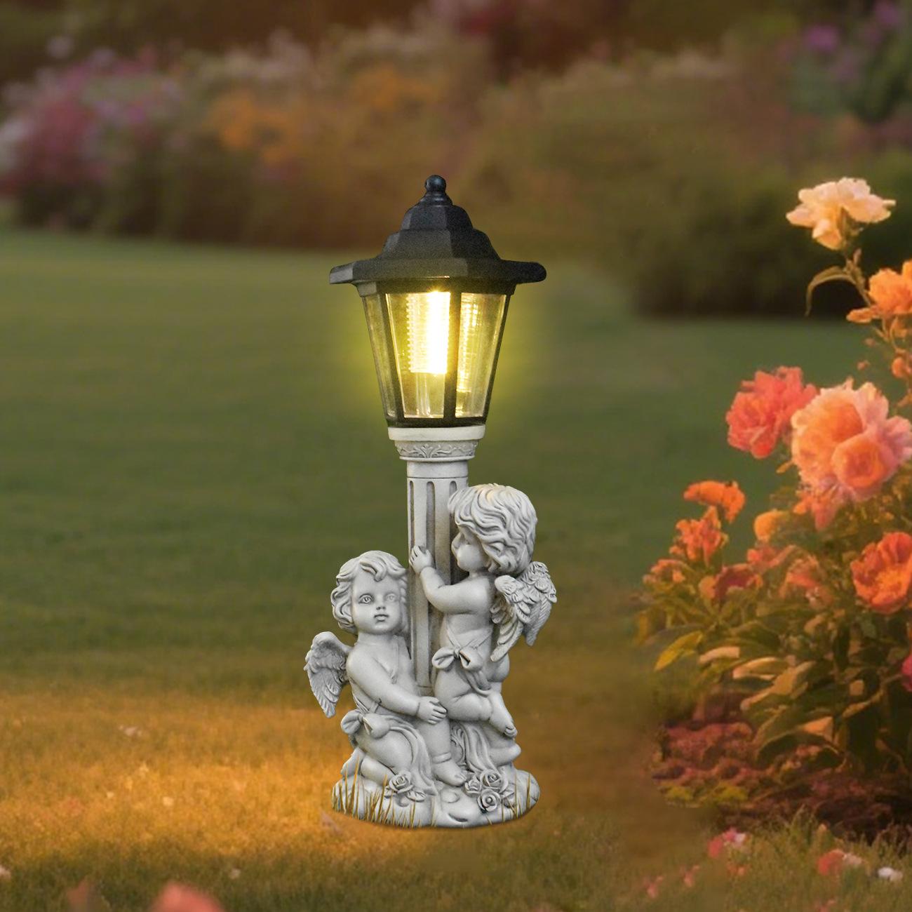 Decorative garden light with angel figures surrounded by flowers and greenery