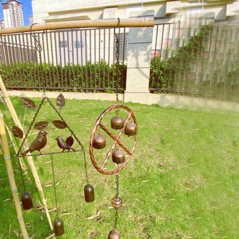 Campana de viento de bronce con rueda redonda, varias campanas colgantes y campana central.