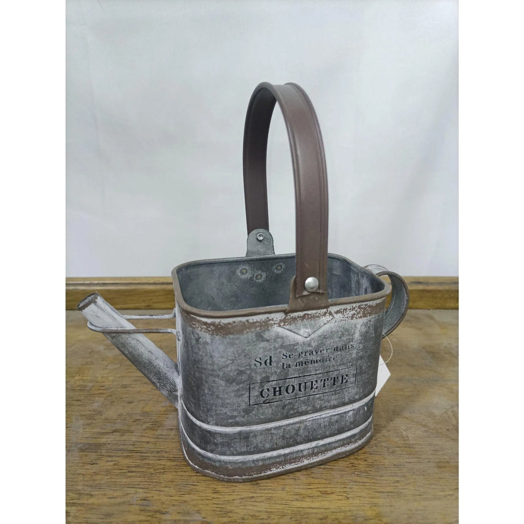 Gray metal watering can planter with brown handle, CHOUETTE label on front