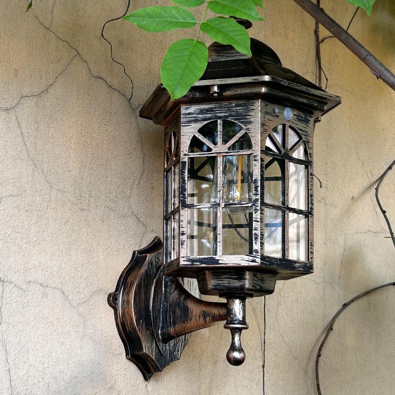 Bronze solar wall lantern with clear glass panels and decorative wall-mount bracket