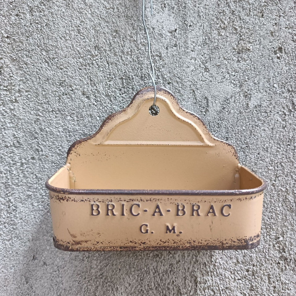 Beige hanging metal wall planter with “BRIC-A-BRAC G.M.” text.