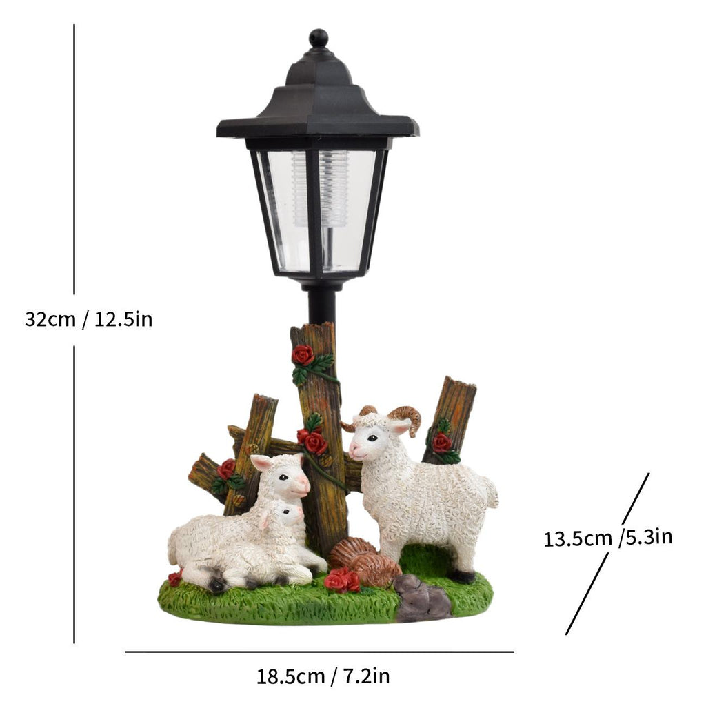Solar LED lantern garden statue with three white lambs and wooden sign posts on grass