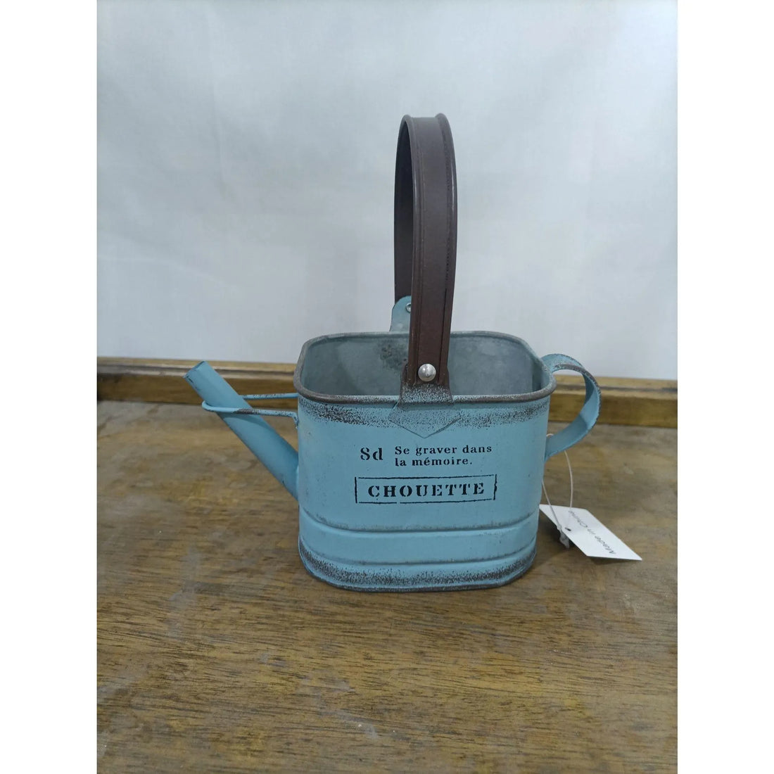 Teal metal watering can planter with dark handle, CHOUETTE label on front