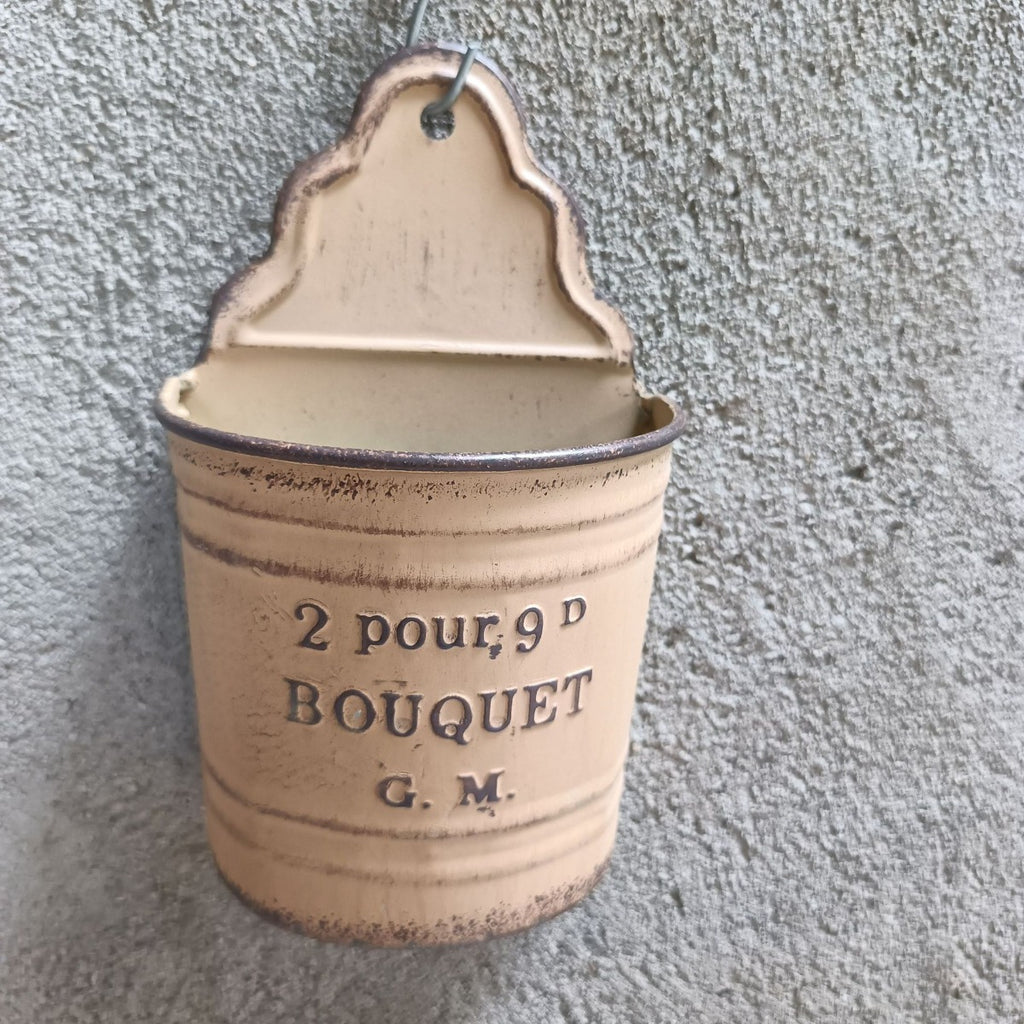 Beige metal wall planter with “2 pour 9D BOUQUET G.M.” text and hanging loop.