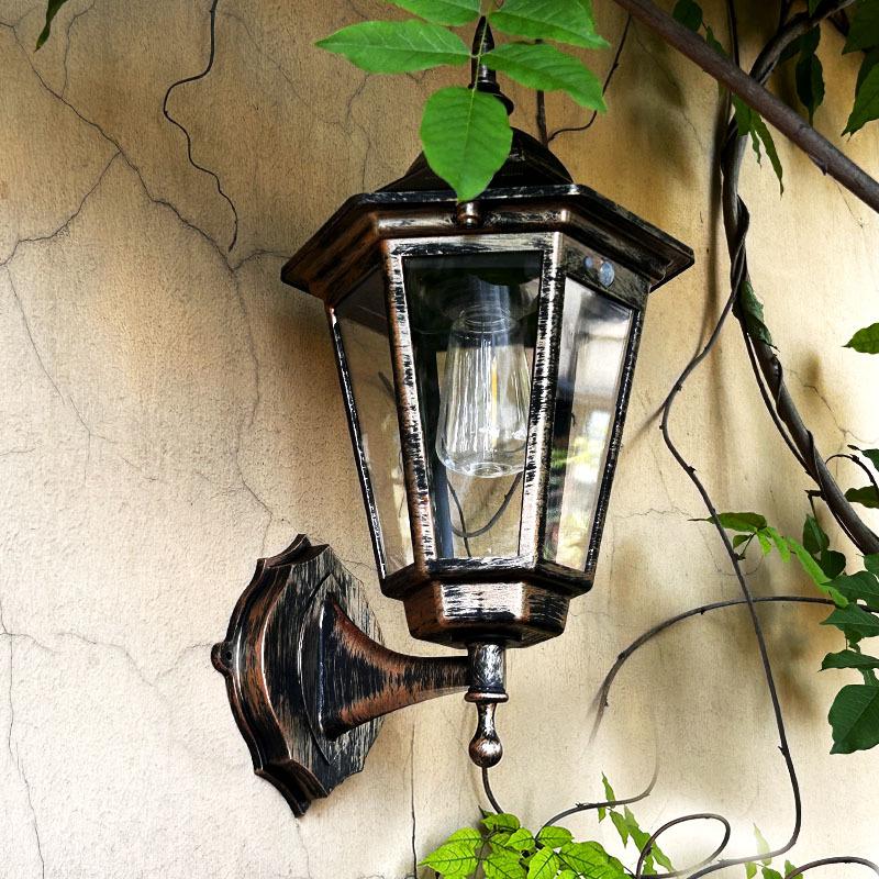 Solar wall sconce lantern with clear glass panels and dark bronze frame, wall-mounted