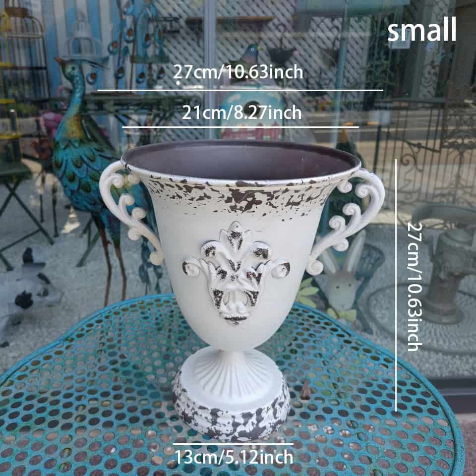 Decorative white vase with intricate designs on a table, with measurements displayed.