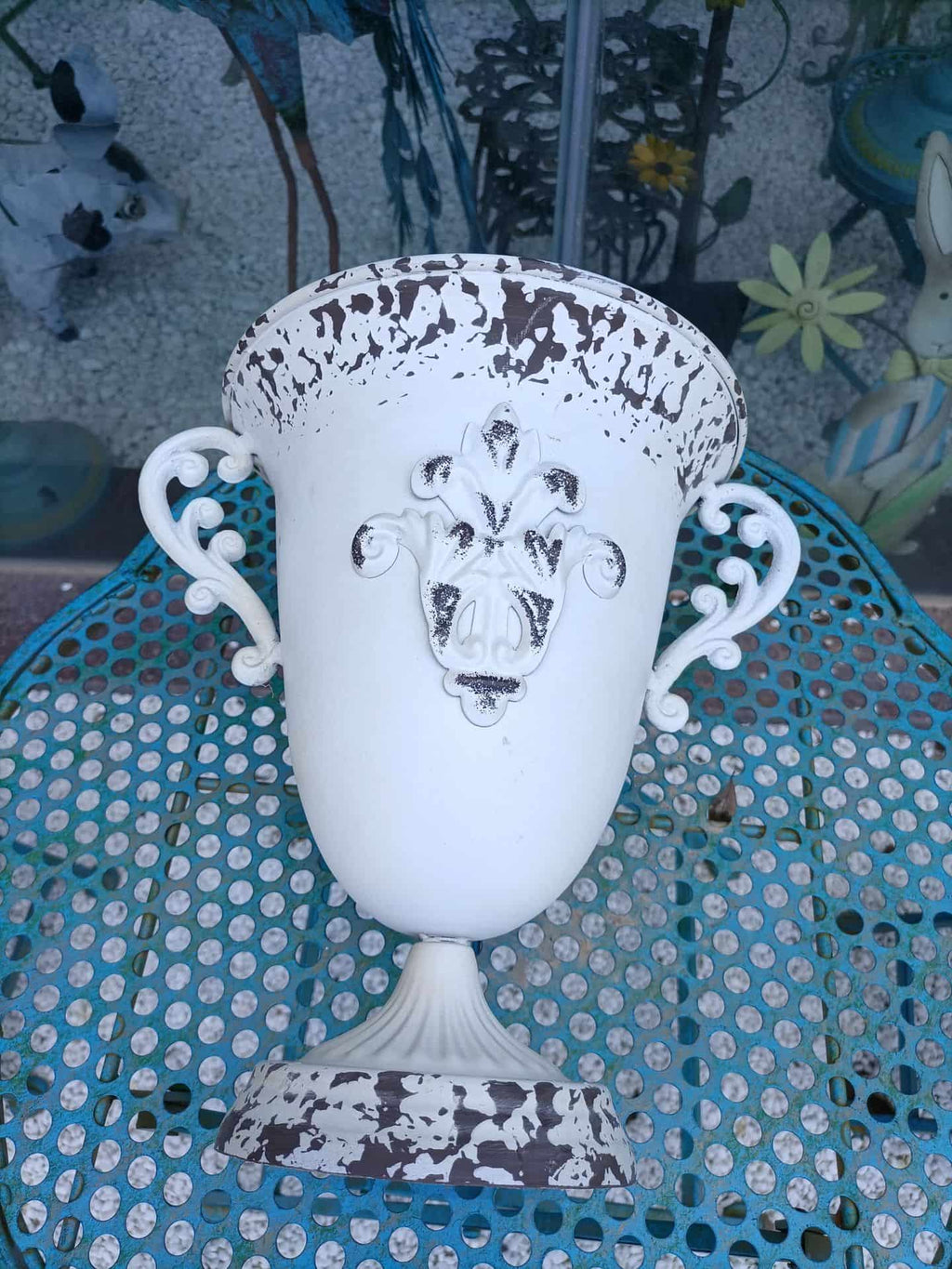 Decorative white urn with intricate design on a textured surface