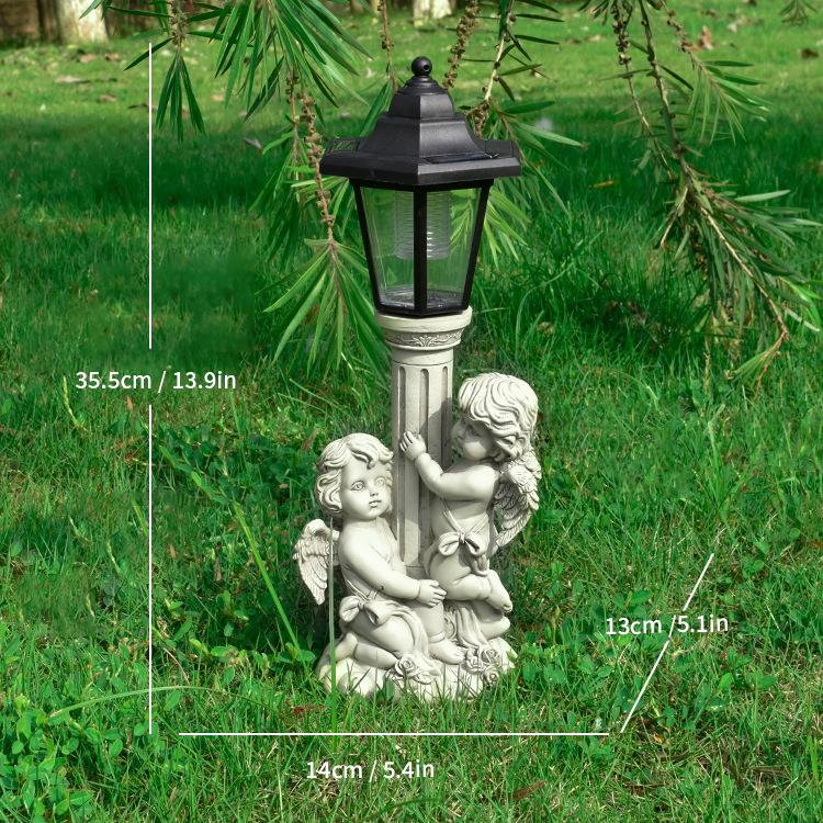 Decorative garden lamp with angel figures on a grassy Size