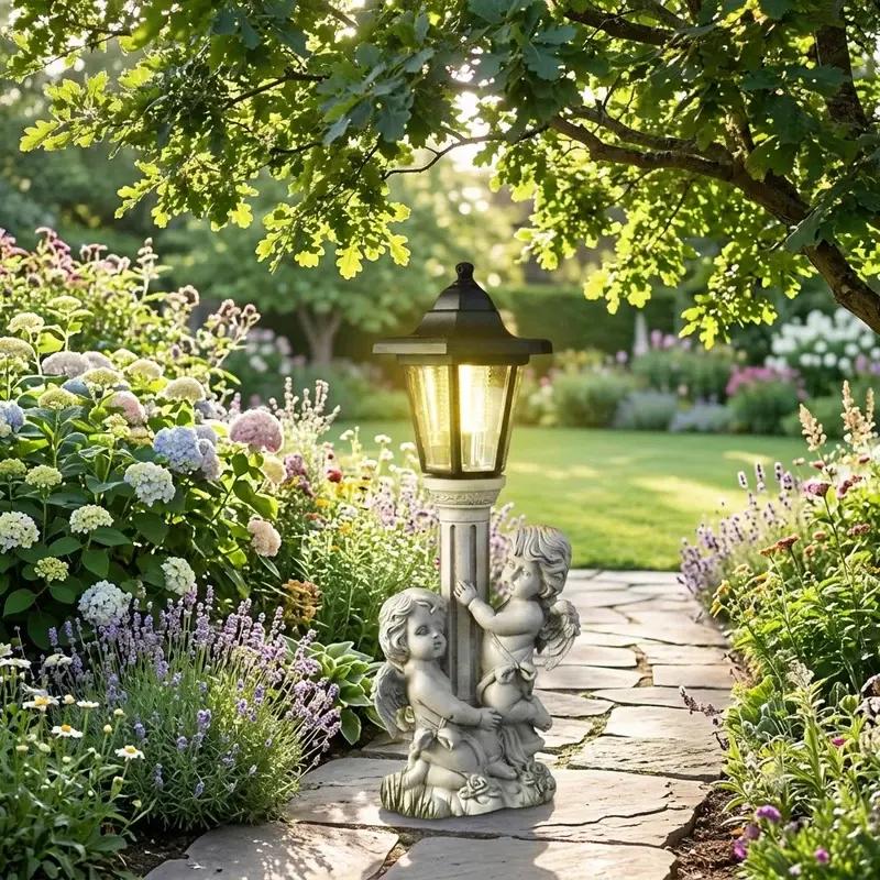 Garden lantern with angel statues on a stone path surrounded by flowers and greenery
