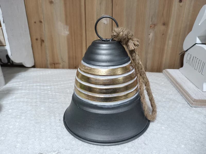 Decorative bell with striped design on a textured surface
