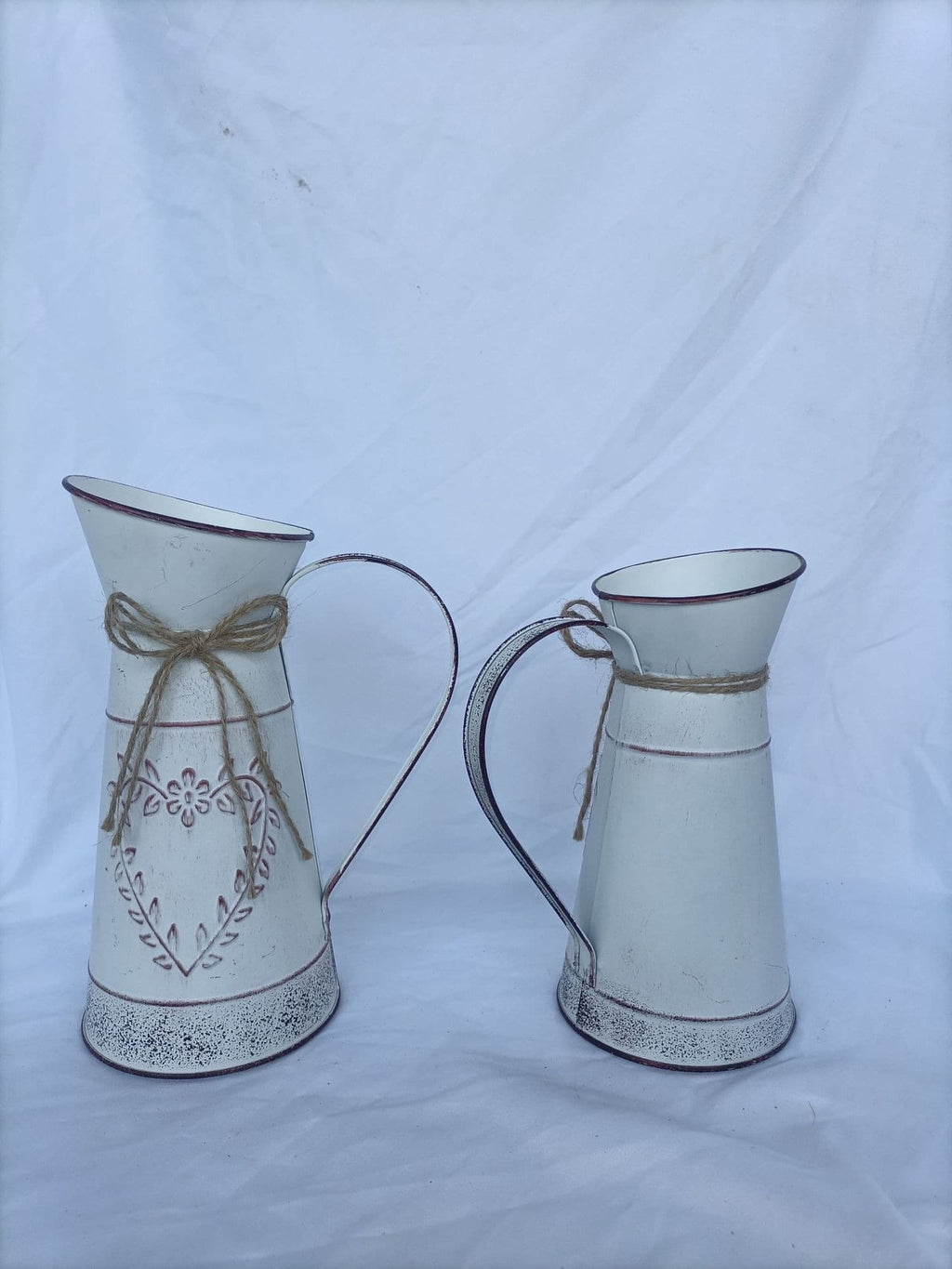 Two decorative jugs with intricate designs on a white background