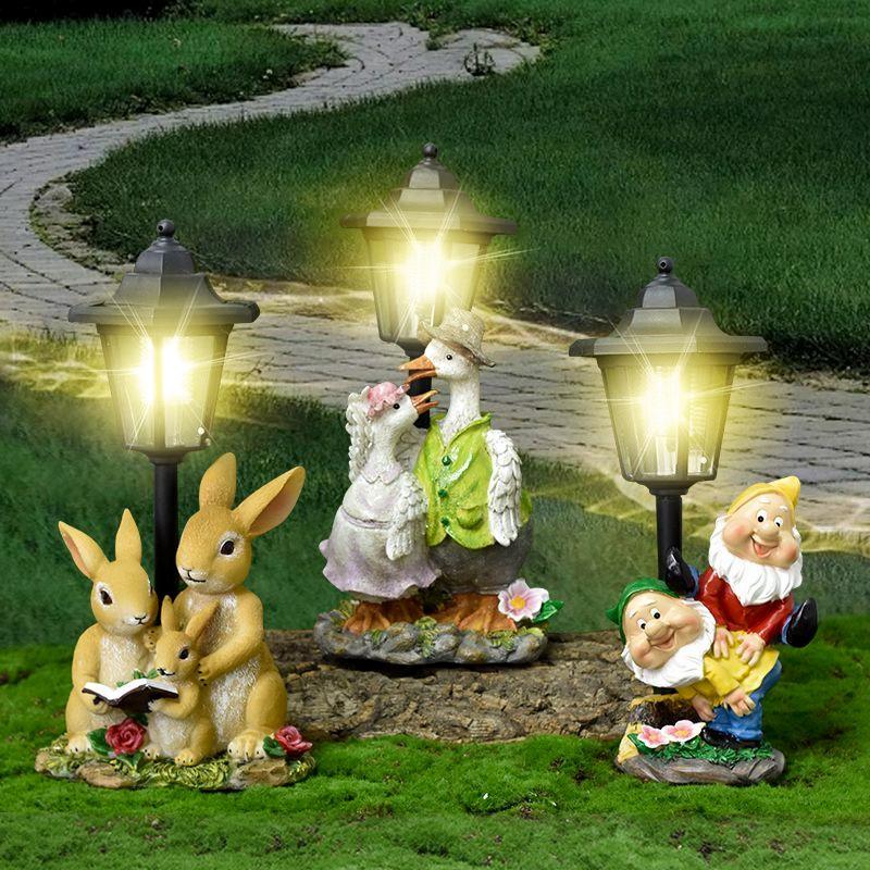 Garden statues including rabbits, a goose, and a gnome with solar lights in the background.
