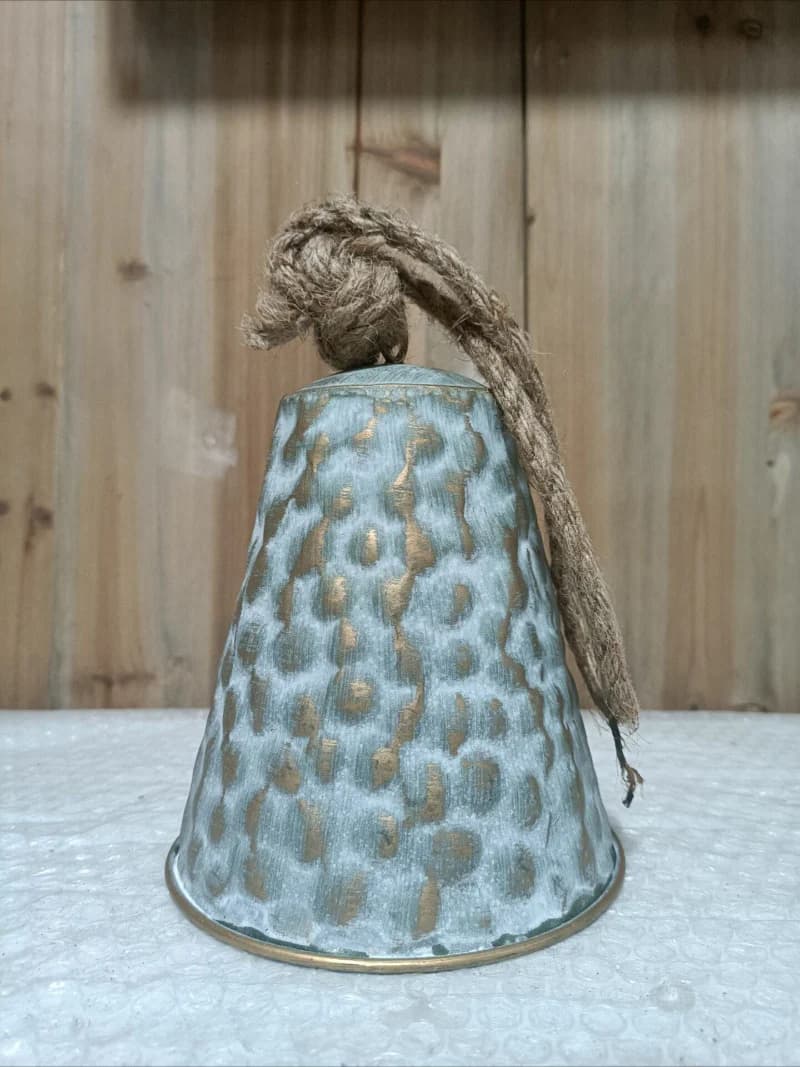 Hammered iron wind chime bell with sage-blue patina and braided jute rope
