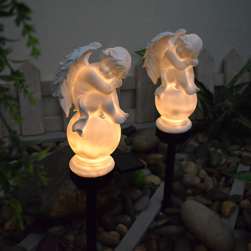 Solar angel stake light showing two glowing winged figures on black posts