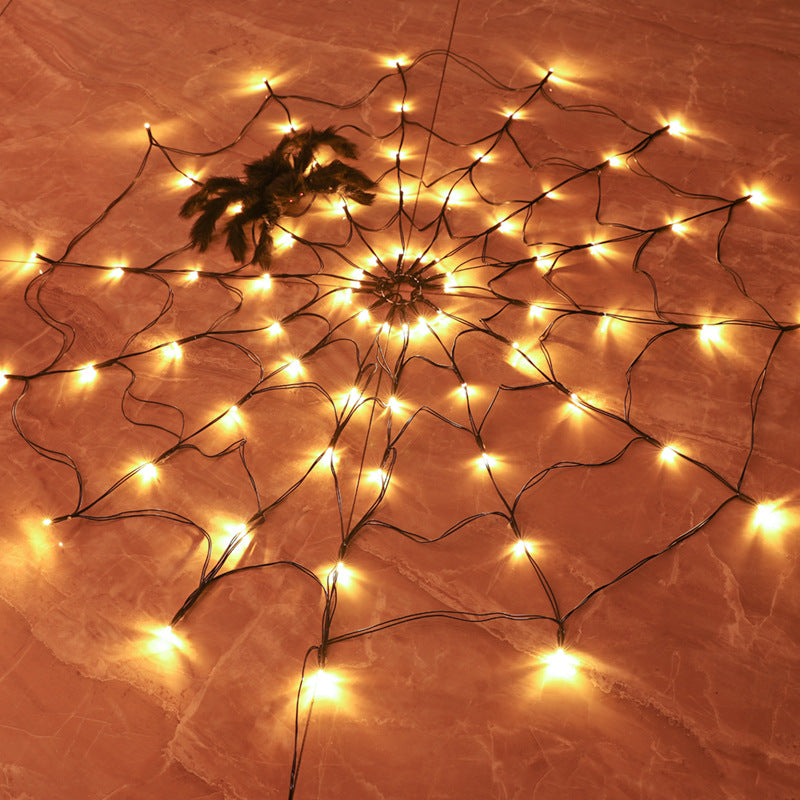Decoración gigante de telaraña LED con luces blancas cálidas y araña central negra.