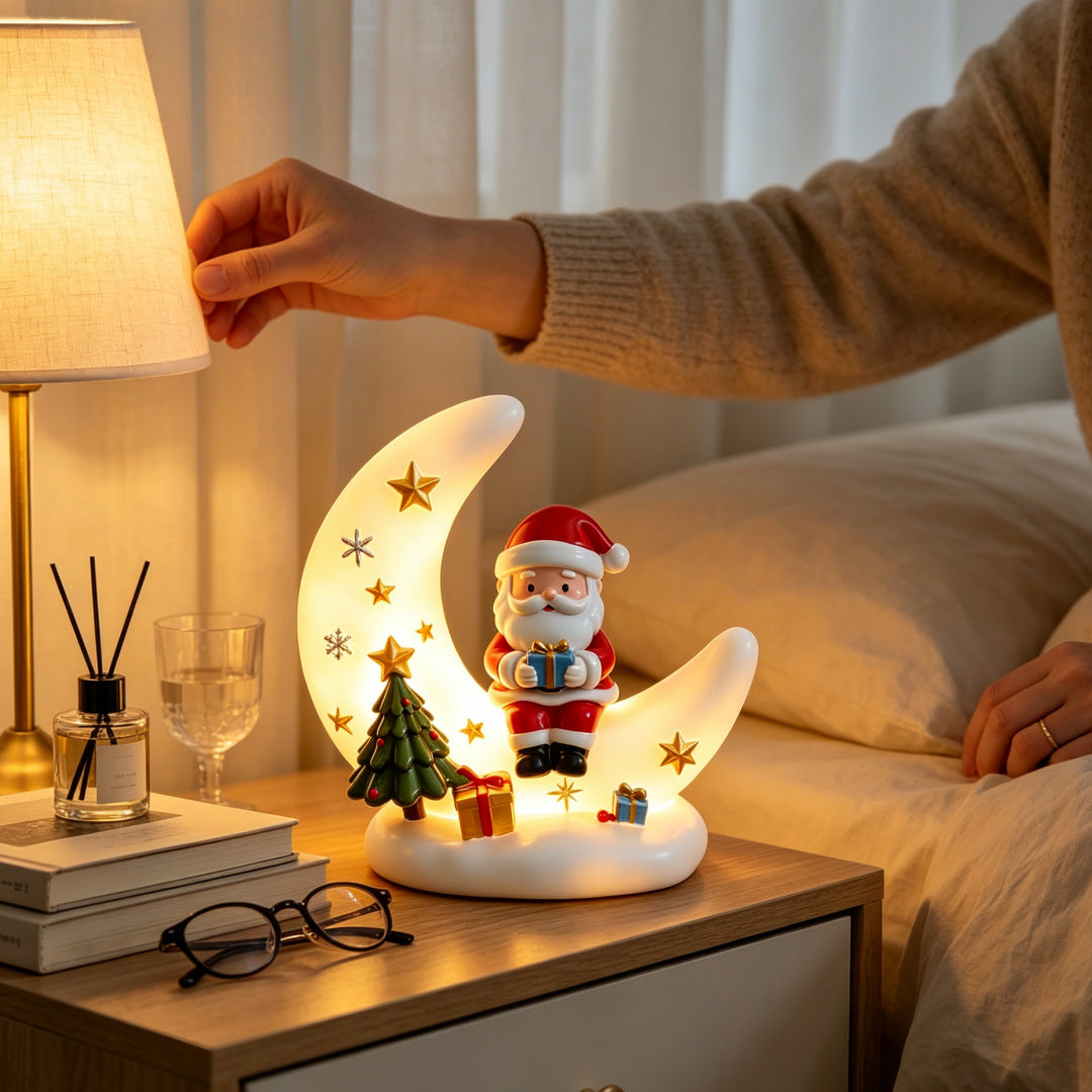 Lámpara de noche de luna de Papá Noel en la mesita de noche con luz cálida y brillante.
