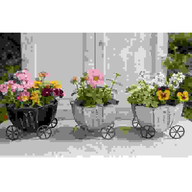 Vintage metal cart planters with wheels holding pink, yellow, and white flowers