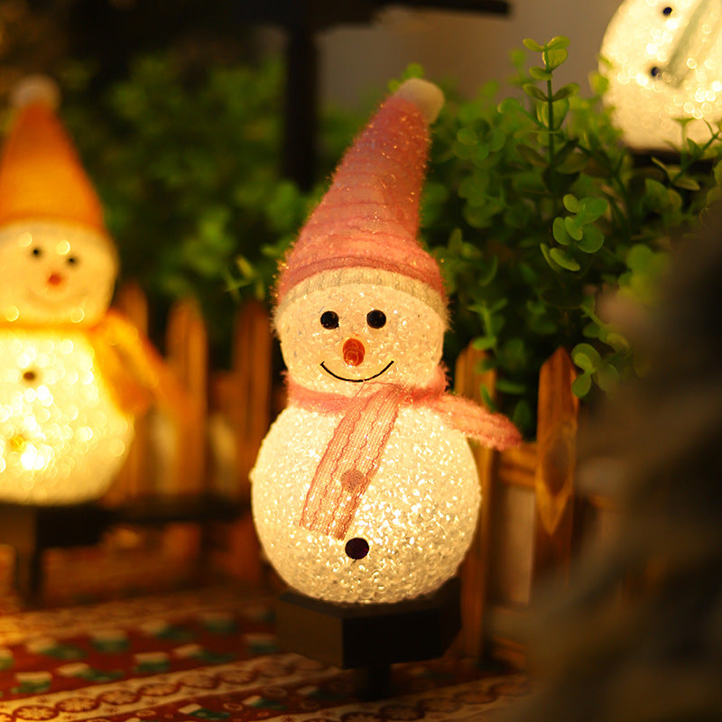 Solar snowman pathway stake light close-up with orange hat and glittered white snowman on stake