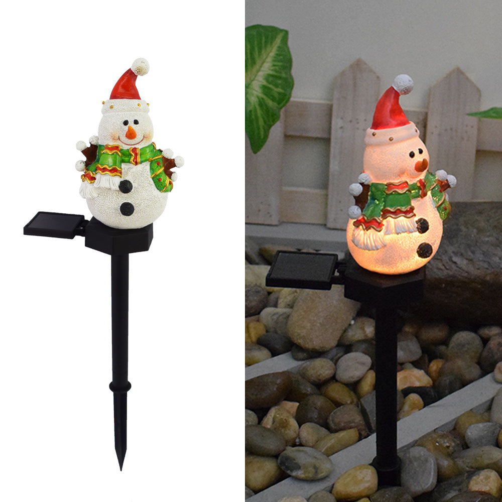 Solar snowman pathway stake light with warm glowing belly and black ground spike
