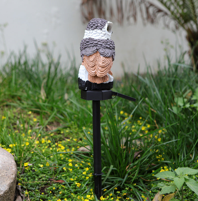 Solar owl garden stake light with gray and white owl head on black post