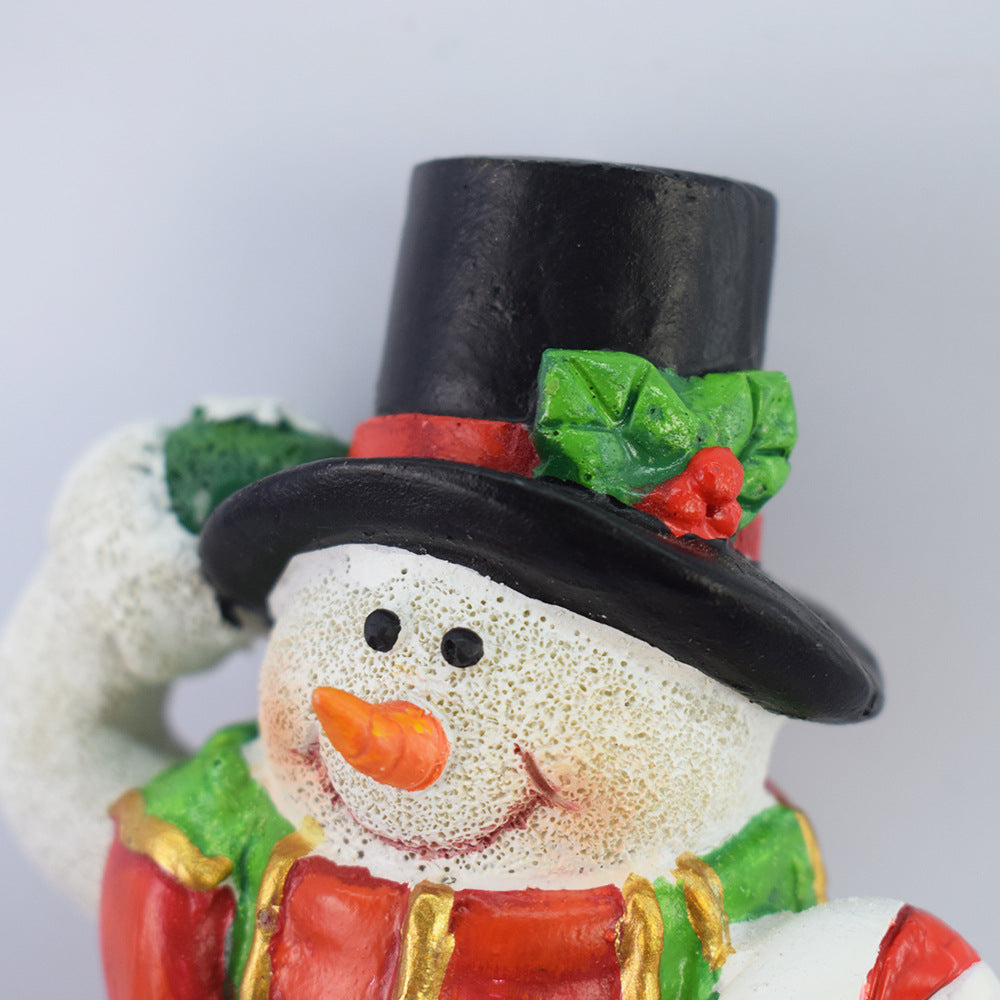 Close-up solar snowman light-up stake wearing black hat and red scarf.