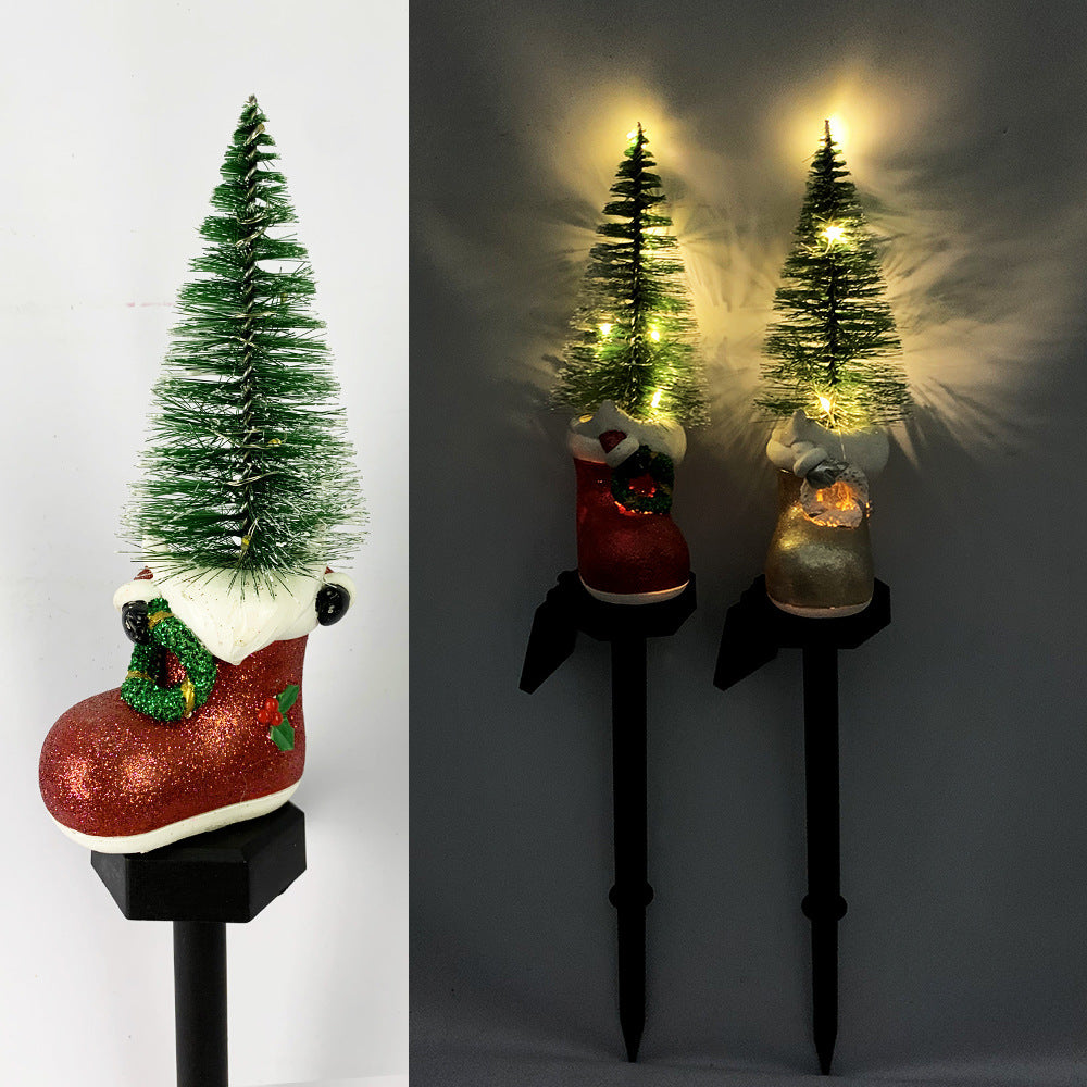 Solar Christmas snowman and green tree light-up pathway stakes in dark holders.