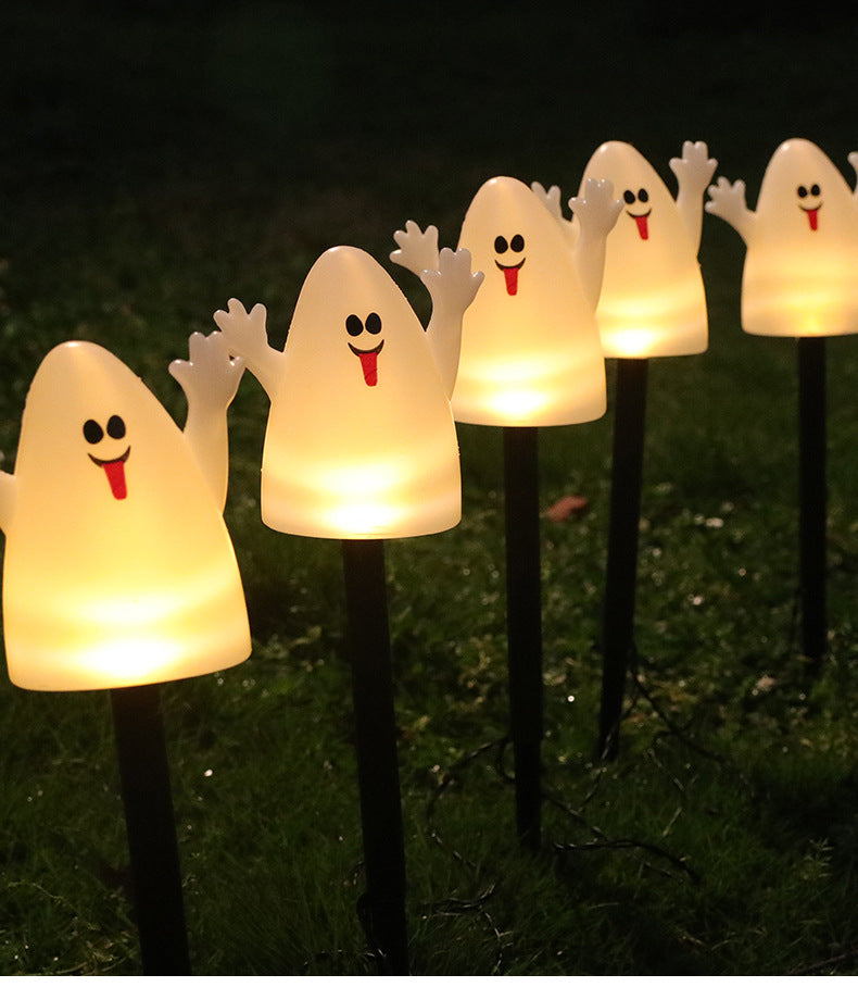 Row of glowing white ghost LED garden stake lights on black stakes