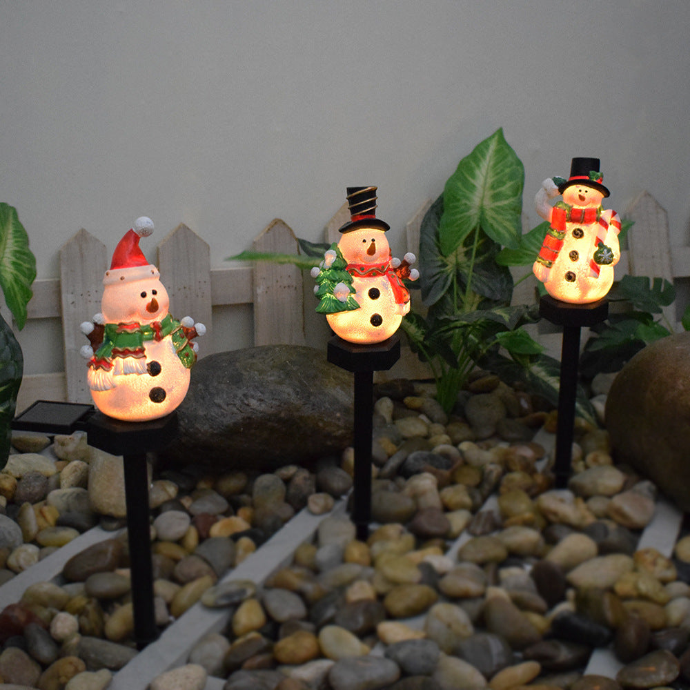 Solar Christmas snowman and Santa light-up pathway stakes with warm LED glow.
