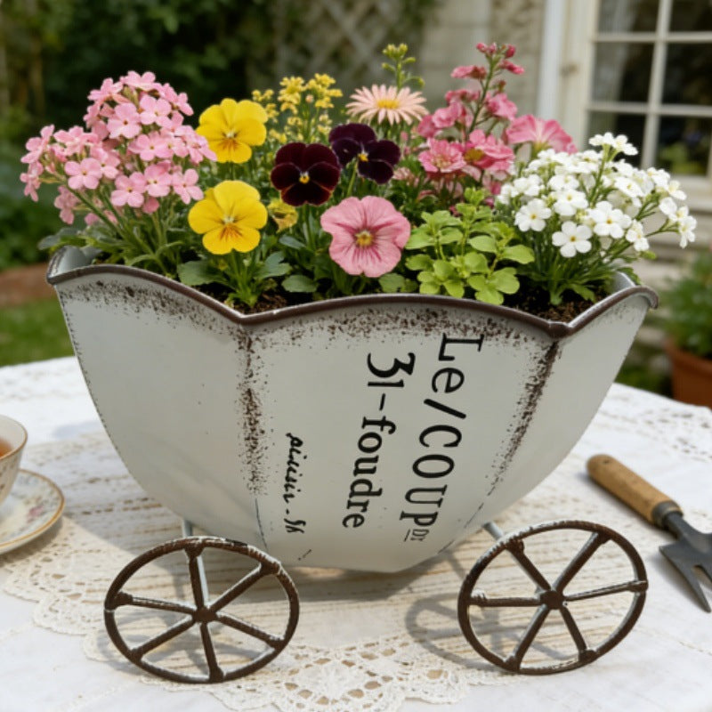 Vintage metal cart planter with light silver finish and floral insert on wheels