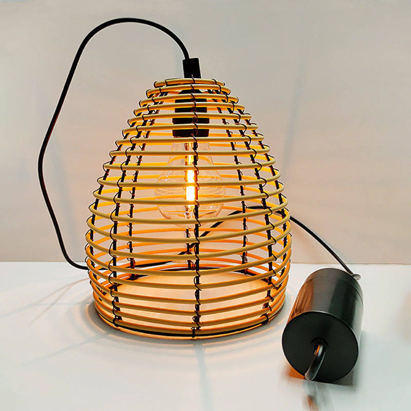 Rattan pendant lantern light close-up with black battery pack and cable