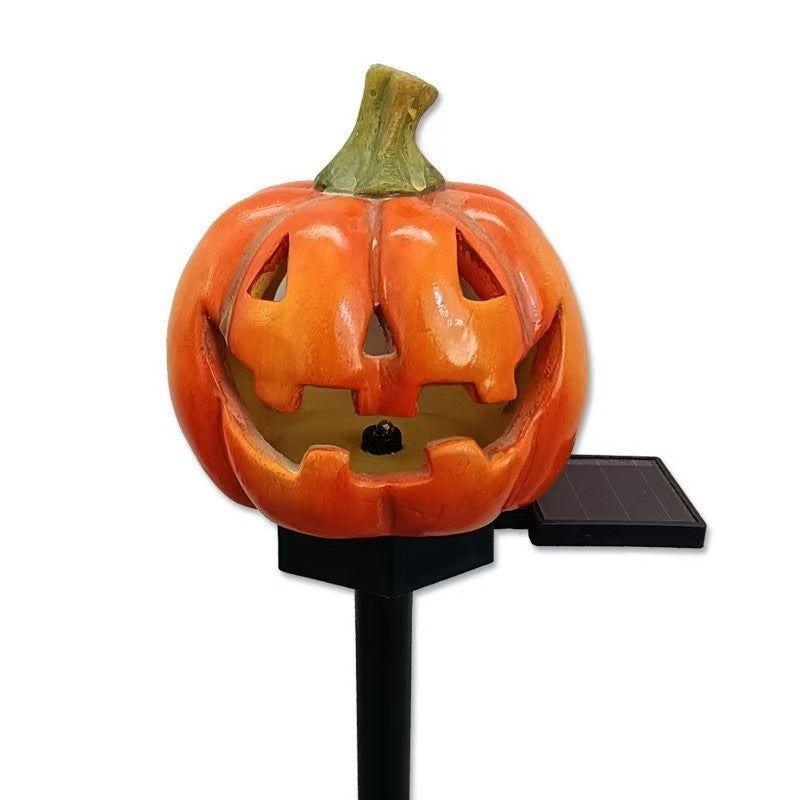 Pumpkin solar stake light with carved jack-o'-lantern painted resin and solar panel.