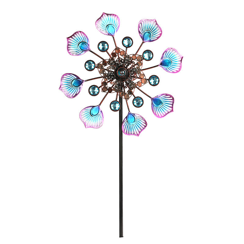 Jeweled peacock wind spinner with purple and teal feather fins and blue gem details