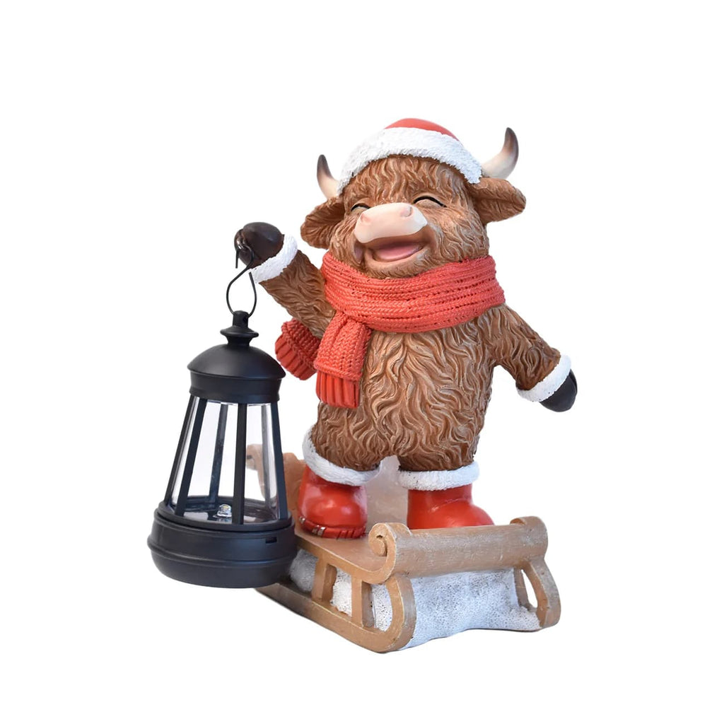 Studio view of a hand-painted cow Christmas solar lantern statue with red scarf