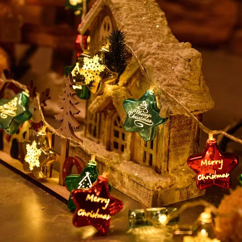 Warm LED string lights with “Merry Christmas” gift tags and small house ornaments
