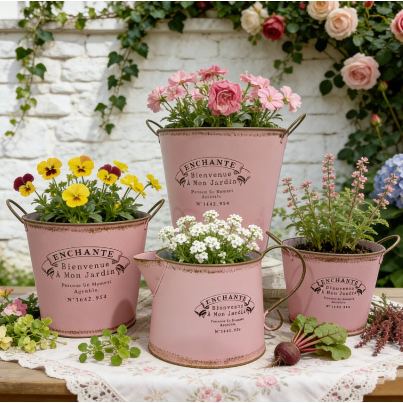 Sæt med 4 vintage lyserøde metalplantekasser med håndtag og assorterede blomster