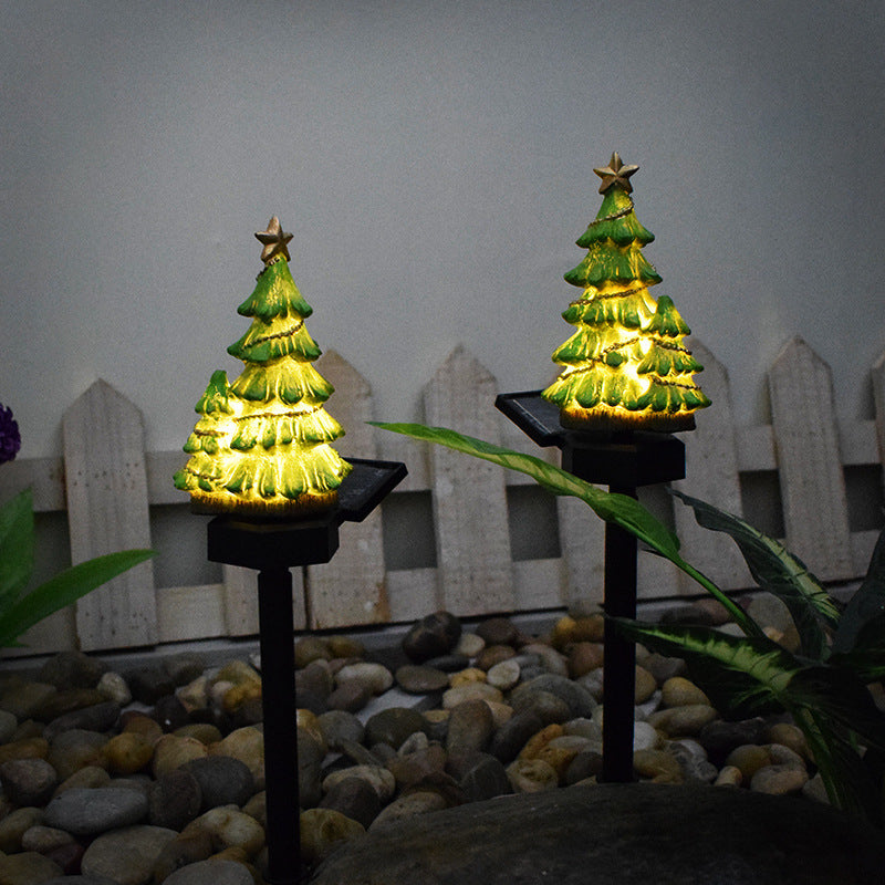 Solar Christmas tree light-up pathway stakes with golden warm LEDs.