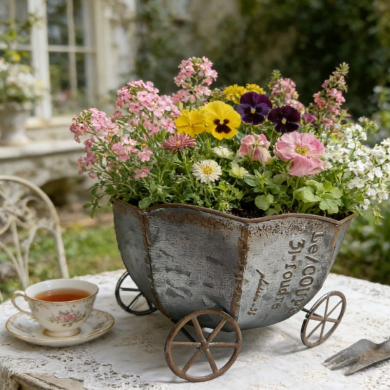 Vintage metalplantevogn med mørkegrå finish og dekorativ blomsterpotteindsats