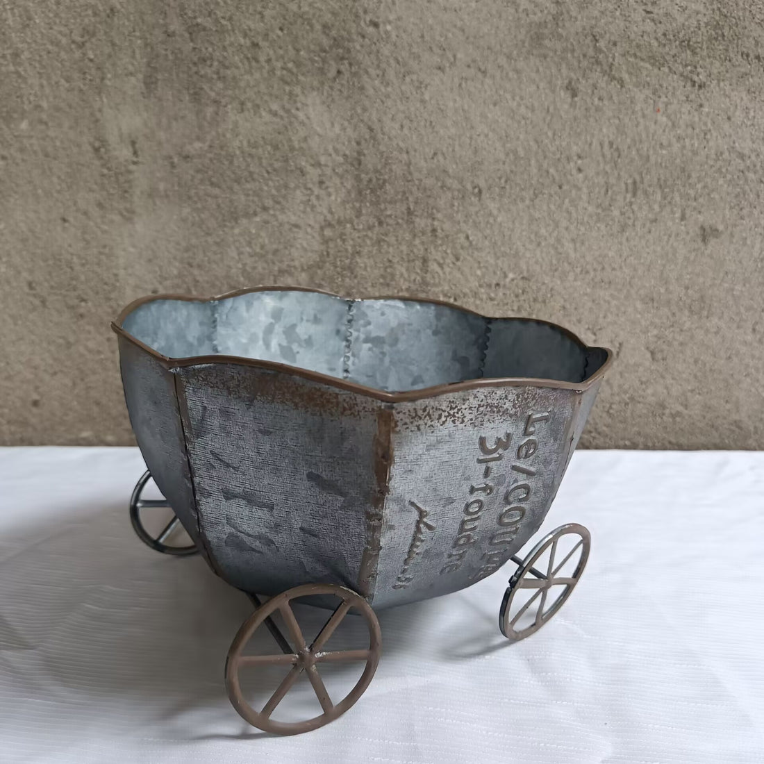 Vintage metal cart planter with dark metal bucket and small round wheel stand