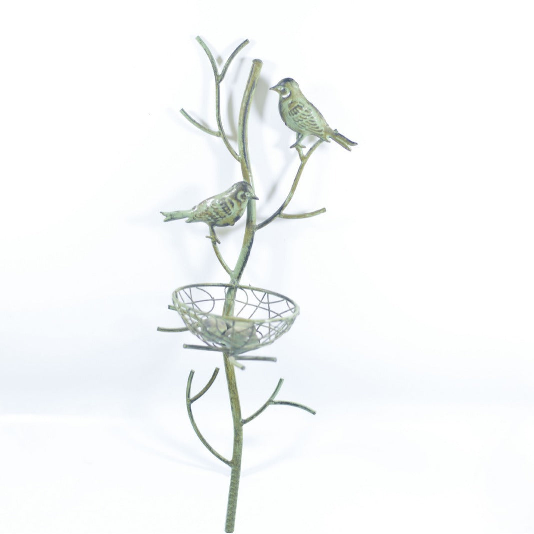 White metal bird trellis stake with two small birds and a wire round nest basket