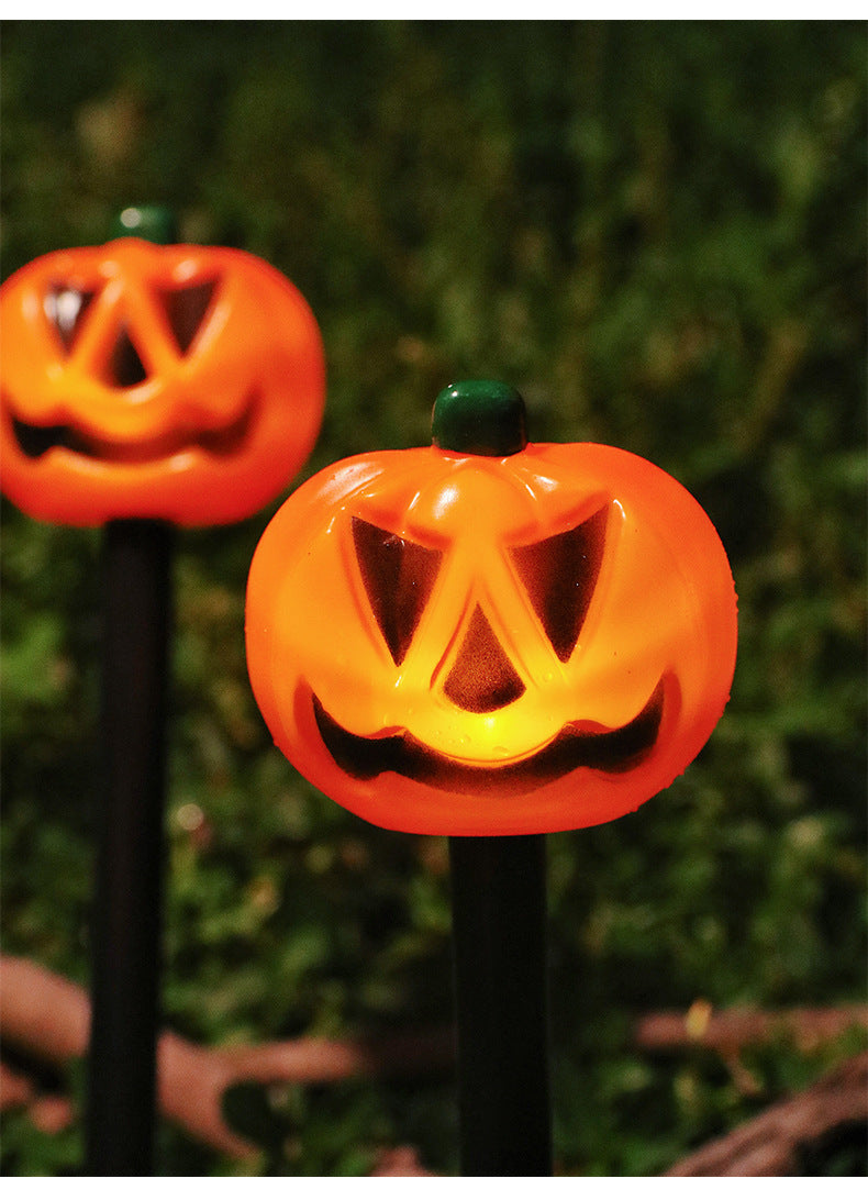 Orange jack-o’-lantern LED garden stake lights with carved grin on black stakes