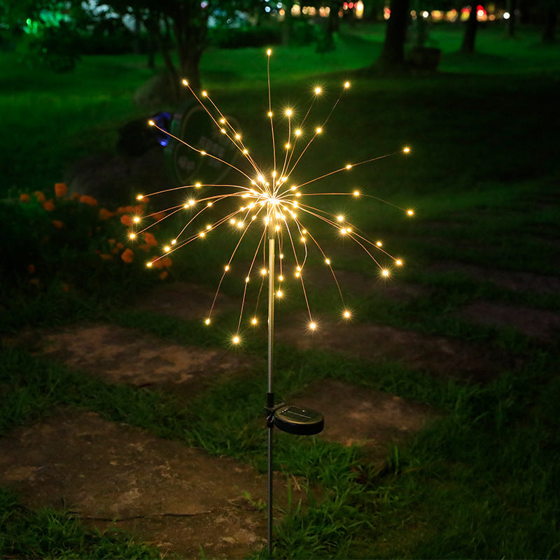 LED solar firework stake light with warm golden starburst glow and round base