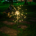 LED solar firework stake light with warm golden starburst glow and round base