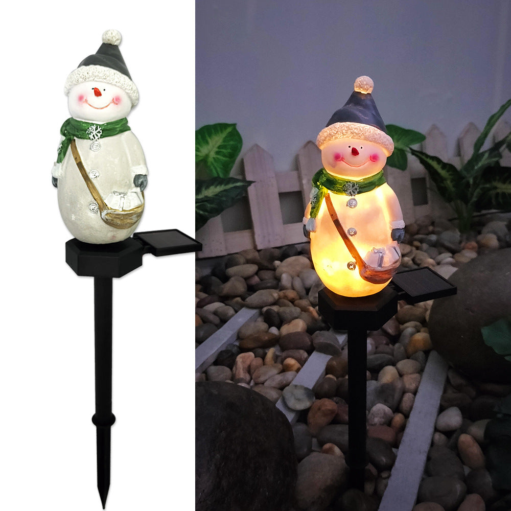 Solar snowman pathway stake light holding a lantern, warm glowing body on black stake