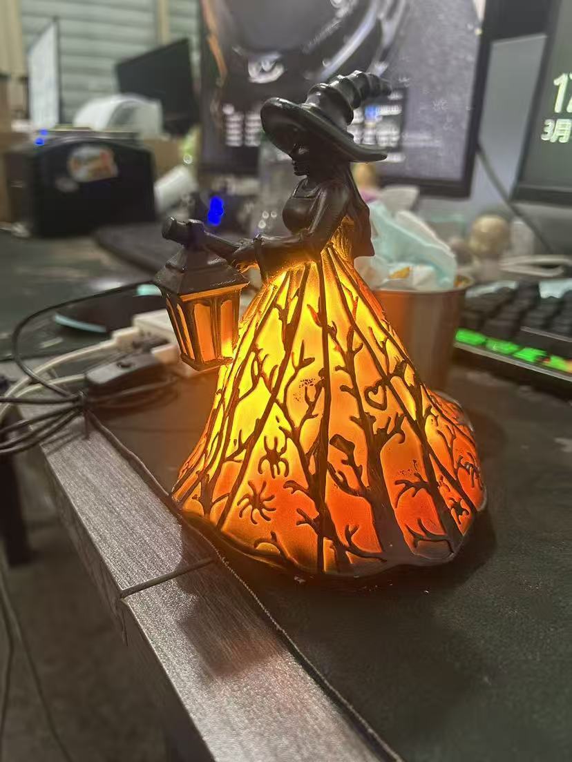 Skrivebordslampe i harpiks med glødende ravfarget lanterne og oransje trelignende mønsterskjerm