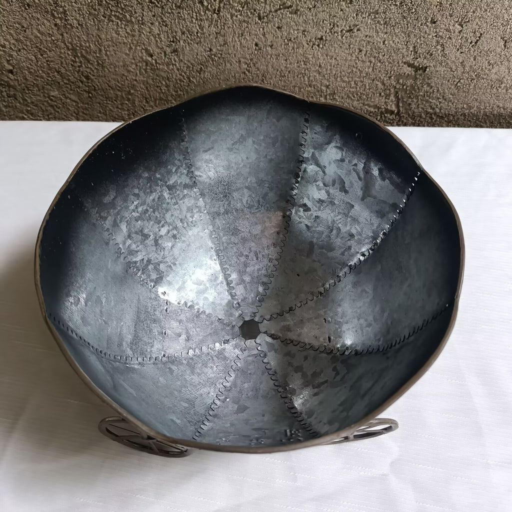 Round metal planter bowl with textured silver interior and four-wheel cart base
