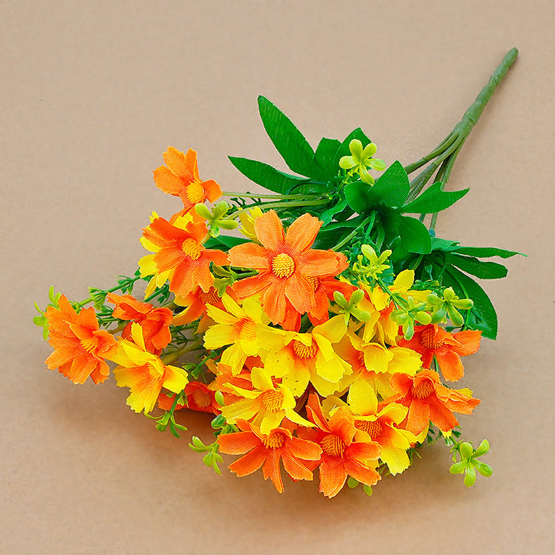 Artificial wildflower stems with orange/yellow faux daisies and green leaves