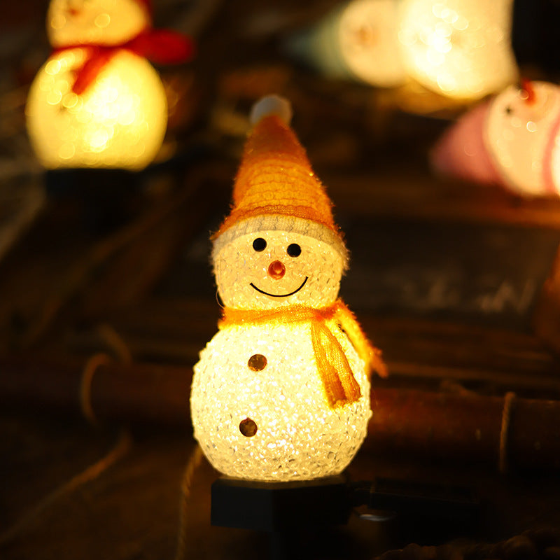 Solar snowman stake light with lit snowman, orange hat and scarf
