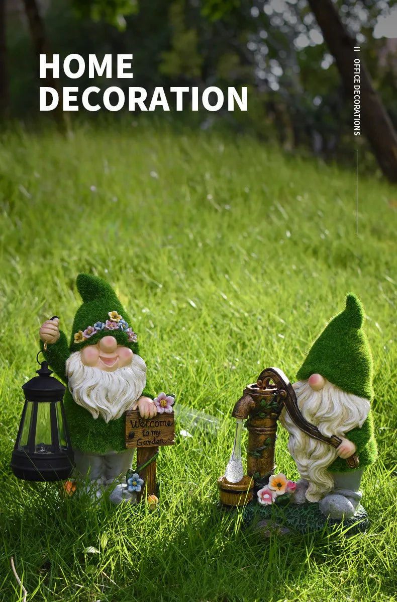 Two resin garden gnomes on grass with glowing LED black lanterns and green cone hats.