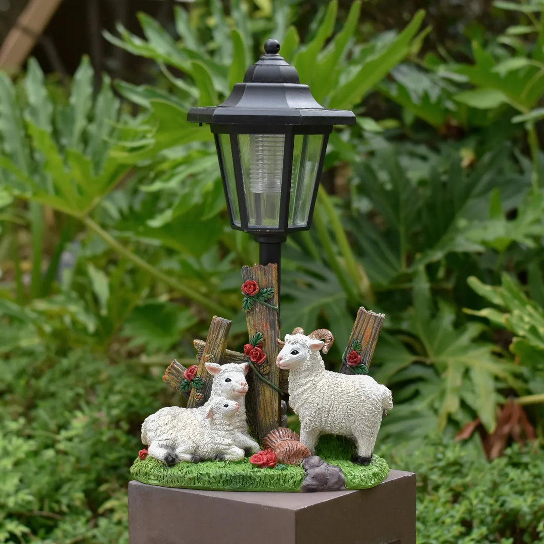 Solar LED garden statue with black lantern and three white lambs on green base