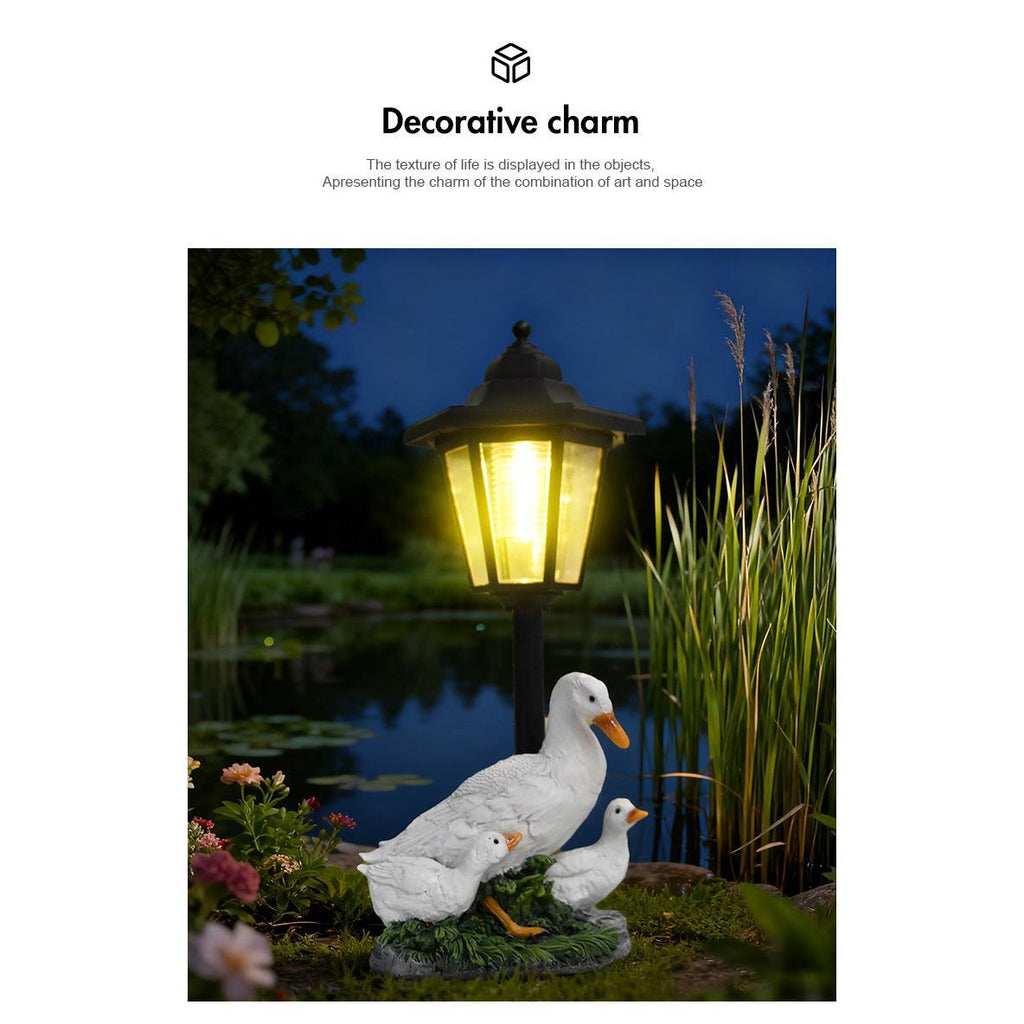 Decorative outdoor light fixture with ducks near a pond at night.